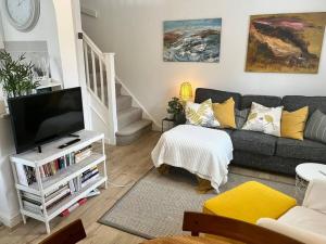 a living room with a couch and a tv at Pass the Keys Cosy One Bedroom House with Parking in Borehamwood