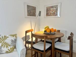 a dining room table with a bowl of fruit on it at Pass the Keys Cosy One Bedroom House with Parking in Borehamwood