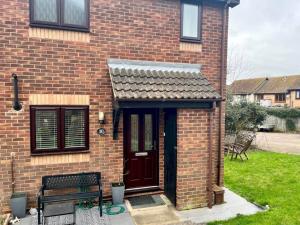 a brick house with a door and a bench at Pass the Keys Cosy One Bedroom House with Parking in Borehamwood