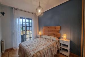 a bedroom with a bed and a large window at Apartamento Saavedra in Posada de Llanes