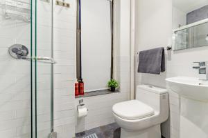 a bathroom with a toilet and a sink at Explore the Authentic Designers 2BD Apartment in Hudson Yards in New York