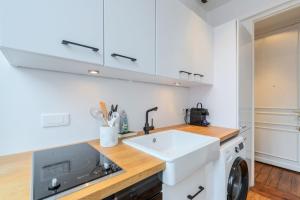 biała kuchnia ze zlewem i pralką w obiekcie Lille Centre apartment with character w Lille