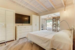 a bedroom with a bed and a flat screen tv at Villa Petit Bijoux by Rentallorca in Can Picafort