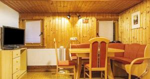 a living room with a table and a television at Fewo Roturach 