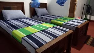 dos camas sentadas una al lado de la otra en una habitación en Sewana Guest INN en Wellawaya