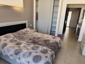 a bedroom with a bed with a comforter on it at Gentle Breeze Studio 1 in Amman