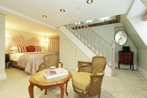 Old Town House by Ezestays, IN THE HEART OF THE OLD TOWN MARGATE في مارغايْت: غرفة نوم بسرير ودرج مع طاولة وكراسي