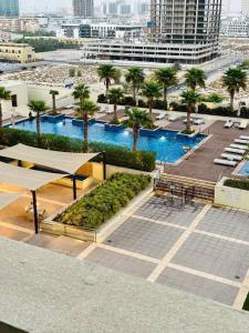 uma vista superior de uma piscina com palmeiras numa cidade em Charming city apartment no Dubai