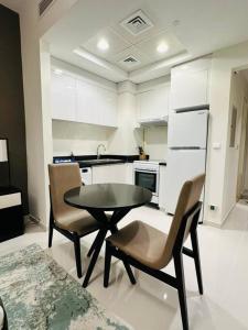 uma cozinha com mesa e cadeiras num quarto em Charming city apartment em Dubai