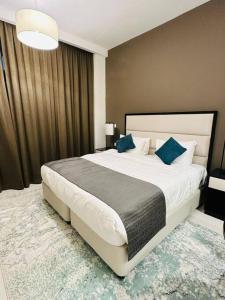 a bedroom with a large white bed with blue pillows at Charming city apartment in Dubai