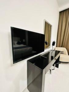 a living room with a large flat screen tv on a wall at Charming city apartment in Dubai
