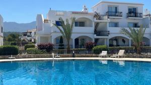 a hotel with a swimming pool in front of a building at Big apartment in Sea Magic in Kyrenia
