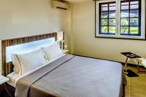 a bedroom with a bed and two windows at Residence Fort Savane in Fort-de-France