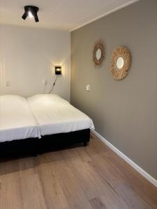 a bedroom with a bed and a mirror on the wall at Puur Texels 9a in De Koog +12 photos