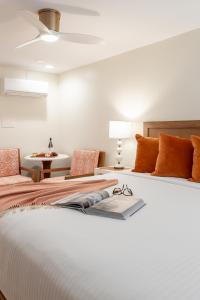 a bedroom with a large white bed with orange pillows at The Beach Club on Madison Avenue in Cape May