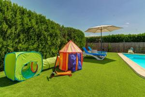a backyard with a pool and a play structure and an umbrella at Finca S'Hostalet by Rentallorca in Montuiri +10 photos