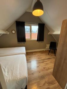 a bedroom with a white bed and a window at Puur Texels 9a in De Koog