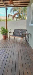 a wooden deck with a bench and a table at Casa Mathia in Caraíva