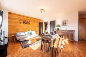 a living room with a table and a couch at Le petit Schuss - A 10min des remontées mécaniques in La Giettaz +4 photos