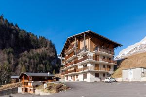 a building in the middle of a parking lot at Le petit Schuss - A 10min des remontées mécaniques in La Giettaz