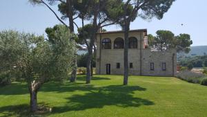 Residenza San Bartolomeo في فولينيو: منزل حجري قديم مع اشجار في الساحه