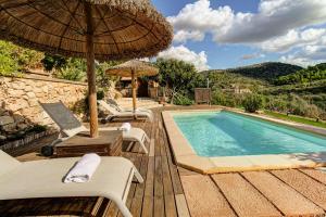 einen Pool mit Stühlen und Sonnenschirmen sowie einen Pool in der Unterkunft Son Cladera Bosch by Rentallorca in Manacor