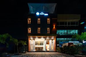 una vista nocturna de un hotel con un cartel en HOTEL AURA GRANDE, en Indore