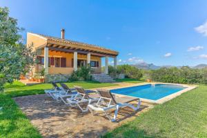 a group of chairs sitting next to a swimming pool at S'Albufereta by Rentallorca in Alcudia