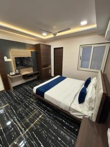 ein großes Schlafzimmer mit einem großen Bett und einem Schreibtisch in der Unterkunft HOTEL AURA GRANDE in Indore
