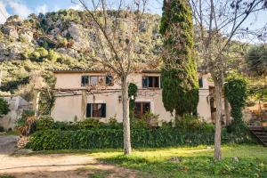 an old house with a mountain in the background at Finca Es Coste by Rentallorca in Pollença