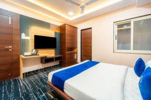 1 dormitorio con 1 cama grande y TV en HOTEL AURA GRANDE, en Indore