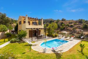 a house with a swimming pool in a yard at Villa Spiridoula in Maroulás