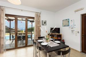 a dining room with a table and a balcony at Villa Spiridoula in Maroulás