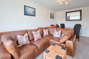 a living room with a brown leather couch at Host & Stay - Spring Gardens in Cayton