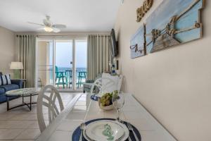 a living room with a dining room table with a view of the ocean at Majestic Sun 806B in Destin