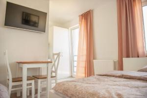 a bedroom with a bed and a table and a window at Słoneczna Bryza in Gąski