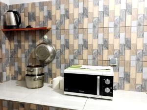 a microwave sitting on a counter in a kitchen at NS Immo Yaounde Cameroun in Yaoundé