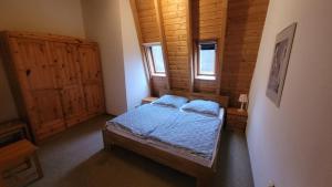 LichtenbergにあるFerienhaus am See Lichtenberg Bayern Frankenwaldseeのベッドルーム1室(青いシーツ付きのベッド1台、窓2つ付)