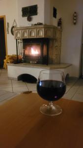 a glass of wine sitting on a table in front of a fireplace at Ferienhaus am See Lichtenberg Bayern Frankenwaldsee in Lichtenberg