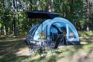 un tavolo e sedie di fronte a una tenda di Luxuswohnzelt ZELT UND SAND direkt am Strand a Dranske