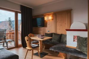 uma sala de estar com um sofá e uma mesa em Parkhotel Holzerhof em Maranza