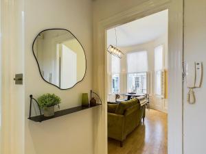 uma sala de estar com um espelho e um sofá em Be London - Notting Hill Apartments em Londres