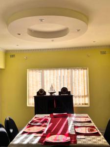 une salle à manger avec une table et un plafond dans l'établissement immaculate 5 bedroomed house, à Bulawayo