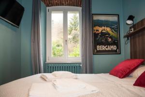 a bedroom with a bed with red pillows and a window at AL NIDO LEGAMI charme e relax in Bergamo
