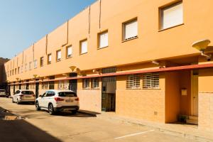 un edificio con coches estacionados frente a él en Casa unifamiliar en Sevilla