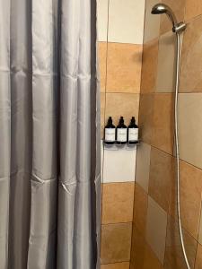 a shower with three bottles of whiskey on a shelf at Chalupa na Lípové v Hlohovci in Hlohovec +47 photos