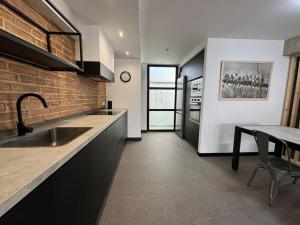 Elegante piso reformado a 1km del centro في غرناطة: مطبخ مع مغسلة وطاولة فيه