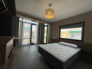 1 dormitorio con cama y ventana grande en Elegante piso reformado a 1km del centro en Granada
