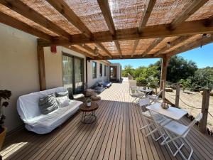 a wooden deck with a couch and chairs on it at Biovilla Sustentabilidade in Palmela