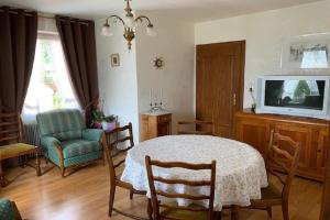 a living room with a table and a tv at ALSACE GITE 5 PERSONNES - 3 CHAMBRES - 2 SDB in Buhl